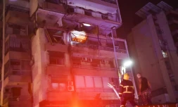 Des pompiers devant un immeuble touché par une frappe aérienne israélienne dans le quartier de Cola à Beyrouth, le 30 septembre 2024