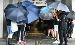 Protesters covered themselves with umbrellas as they gathered outside the Eastern District Courts in Hong Kong