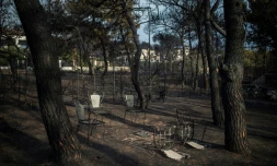 Une table et des chaises brûlées dans un jardinaprès l'incendie meurtrier qui a dévasté Mat, le 24 juillet 2018  près d'Athènes