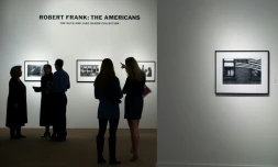 Des visiteurs regardent des images du photographe Robert Frank tirées de son livre "Les Américains", lors d'une exposition à Sotheby's à New York (Etats-Unis), le 17 décembre 2015