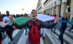 Un manifestant avec un drapeau algérien proteste contre un éventuel 5e mandat du président algérien Abdelaziz Bouteflika, le 22 février 2019 à Alger