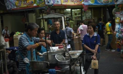 Un vendeur prépare à manger dans une allée du quartier chinois de Bangkok, le 12 avril 2016