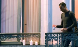 Mohamed Abdeslam, le frère d'un des kamikazes qui s'est fait sauter à Paris, dispose discrètement des bougies au balcon de la maison familiale, le 18 novembre 2015 à Molenbeeck