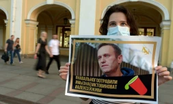 Une femme tient le portrait de l'opposant russe Alexeï Navalny à Saint-Pétersbourg, le 20 août 2020