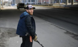 Un civil ukrainien armé d'un fusil protÚge une route à Kiev, le 25 février 2022