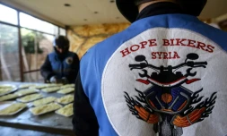 Des membres du club de motards "Hope Bikers Syria" préparent la distribution de repas aux personnes dans le besoin pendant le ramadan, le 25 mars 2024 à Damas, en Syrie