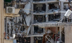 Des secouristes israéliens fouillent les décombres d'un bâtiment touché par des tirs de missiles iraniens dans la ville côtière de Bat Yam, au sud de Tel-Aviv, le 15 juin 2025