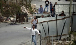 Des manifestants palestiniens jettent des pierres sur des soldats israéliens, dans le village de Sair, près d'Hébron en Cisjordanie, le 26 octobre 2015