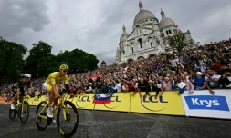 Le maillot jaune Tadej Pogacar et le Belge Wout Van Aert passent devant la basilique du Sacré-Cœur sur la Butte Montmartre, lors de la 21e et dernière étape du Tour de France, le 27 juillet 2025