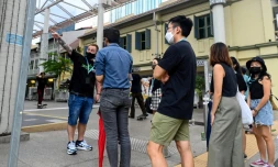Bruce Mathieu (G) un ancien membre des sociétés secrètes, dirige une visite guidée sur les traces des triades dans le quartier financier de Singapour le 19 juin 2021