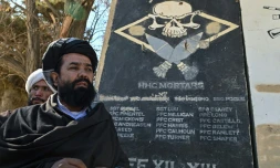 Le mollah Habibullah Mujahed, responsable taliban de la culture à Ghazni, se tient près d'un mur portant les noms de soldats américains, le 15 novembre 2021 à Ghazni, au sud de Kaboul