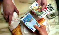 Une personne achète sa baguette de pain, le 2 janvier 2002, dans une boulangerie de Lille, avec un billet de 20 euros