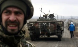 Un observateur de l'OSCE prÚs d'un tank lors d'une mission d'observation du retrait des forces ukrainiennes prÚs du village de Bogdanivka, dans la région de Donetsk en Ukraine, le 9 novembre 2019