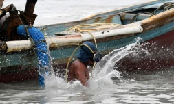 Un homme s'apprête à plonger pour remuer la vase et ramener de l'étain au large de l'île de Bangka, en Indonésie, le 10 novembre 2016