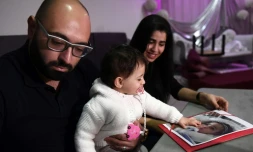 Sacha, 15 mois, touche une photo de sa soeur jumelle Marwa lors d'une conférence de presse de leur père Mohamed Bouchenafa, le 4 mars 2017 à Marseille