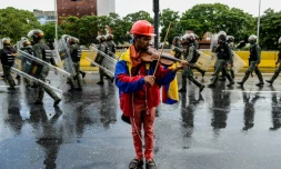 L'opposant Wuilly Arteaga joue du violon davant la police antiémeute, le 24 mai 2017 à Caracas, au Venezuela