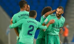 L'attaquant français du Real Madrid, Karim Benzema (d), félicité par ses coéquipiers après son but lors du match de Liga face à la Real Sociedad, à San Sebastian, le 21 juin 2020