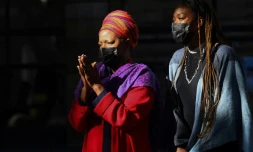 Mpho Tutu (G), fille de l'archevèque sud-africain et prix Nobel de la paix Desmond Tutu,  avec sa propre fille Nyaniso Burris, arrive à la cathédrale du Cap avec le cortège amenant le cercueil de son père, le 31 décembre 2021