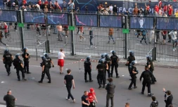 Des policiers en position près des barrières entourant le Stade de France pour empêcher des tentatives d'intrusion d'individus sans billet, lors de la finale de Ligue des champions, le 28 mai 2022 à Saint-Denis, au nord de Paris