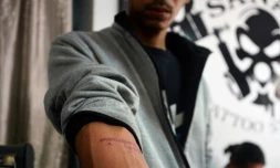 Un homme montre le 6 février 2021 à Naypyidaw, en Birmanie, son tatouage sur lequel on peut lire les paroles d'une chanson révolutionnaire: "Kabar Ma Kyay Bu"" ("Nous tiendrons jusqu'à la fin du monde"), en signe de protestation aprÚs le coup d'Etat