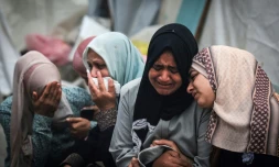 Des Palestiniens pleurent des proches après une frappe israélienne sur le camp de réfugiés d'al-Maghazi, le 25 décembre 2023 à Deir el-Balah, dans le centre de la bande de Gaza