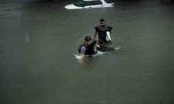 Des gens tentent de sortir de l'eau dans les rues inondées de Galveston au Texas, après le passage de la tempête Harvey le 26 août 2017