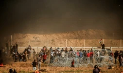 Des Palestiniens jettent des pierres aux soldats israéliens massés de l'autre côté de la frontière entre Israël et la bande de Gaza, le 27 juillet 2018