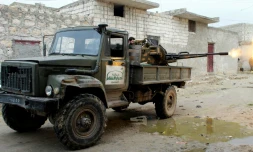 Un rebelle du groupe islamiste Ahrar al-Sham, faisant partie d'une coalition de groupes rebelles, tire sur des positions des forces gouvernementales syriennes près d'Alep, le 27 janvier 2014