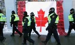 Des policiers passent devant un drapeau canadien près du Parlement à Ottawa, le 7 février 2022