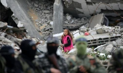 Un enfant passe derrière des combattants de la branche armée du Hamas qui assistent aux obsèques d'un haut commandant du Hamas, Marwan Issa, tué en mars 2024, à Bureij, dans le centre de la bande de Gaza, le 7 février 2025