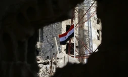 Le drapeau national syrien hissé par les forces de Bachar al-Assad dans le centre-ville de Deraa, berceau de la révolte contre son régime, le 12 juillet 2018