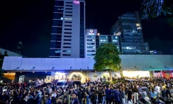 Les employés du centre d'appels surfent sur leurs téléphones portables alors qu'ils se rassemblent devant leur immeuble de bureaux après les secousses du tremblement de terre à Cebu, dans le centre des Philippines, le 30 septembre 2025