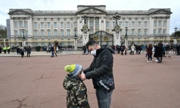 Un père ajuste le masque de protection de son fils, le 14 mars 2020 à Londres