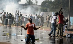 Un partisan de l'opposition gabonaise prie devant les forces de l'ordre à Libreville lors d'une manifestation de l'opposition contre la réélection d'Ali Bongo, le 31 août 2016
