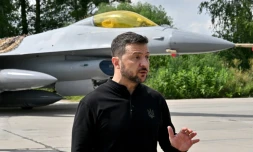 Le président ukrainien Volodymyr Zelensky devant un chasseur F-16 lors d'une cérémonie dans un lieu tenu secret en Ukraine, le 4 août 2024