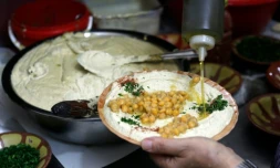 Un restaurateur palestinien prépare un plat de hoummous, purée froide à base de pois chiches, dans la vieille ville de Jérusalem, le 12 septembre 2015