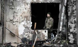 Un membre des forces ukrainiennes dans un immeuble touché par une frappe russe dans la banlieue de Kiev, le 25 février 2022