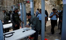 Un palestinien vide ses poches près du portique détecteur de métaux installé près de la porte des Lions, l'une des principales entrées de la Vieille ville de Jérusalem, le 16 juillet 2017