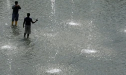 Des personnes se rafraichissent dans une fontaine lors de grosses chaleurs à Singapour, le 21 juin 2010