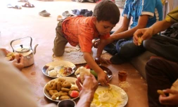 Une famille syrienne évacuée de la ville de Daraya, reprise par le régime, partage un petit déjeuner à son arrivée à Hrajela le 27 août 2016