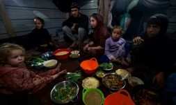 Une famille palestinienne rompt le jeûne au deuxiÚme jour du ramadan dans un camp pour personnes déplacées à Rafah, dans le sud de la bande de Gaza, le 12 mars 2024
