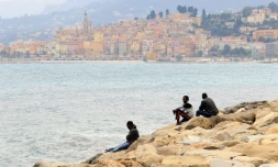 Des migrants regardent la mer à Vintimille, à la frontière franco-italienne, tout près de la ville française de Menton, en arrière-plan, le 13 juin 2015