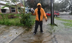 Un habitant de Jacksonville marche dans une rue inondée, aprÚs le passage de l'ouragan Matthew, le 7 octobre 2016 en Floride