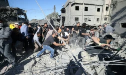 Des secouristes fouillent les décombres laissés par une frappe israélienne dans la banlieue sud de Beyrouth, le 22 octobre 2024