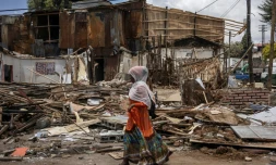 Une femme passe devant des ruines de maisons démolies dans le quartier historique de Piassa à Addis Abeba, le 14 mars 2024