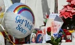 Des ballons et des bougies déposés au pied de la statue de Jean-Paul II devant l'hôpital Gemelli où est hospitalisé le pape François, le 23 février 2025 à Rome
