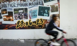 Un cycliste passe, à Nanterre le 6 juin 2024 devant une fresque en hommage à  Nahel, tué à 17 ans le 27 juin 2023 par un policier lors d'un contrôle 