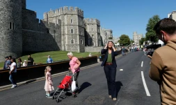 Une journaliste de TF1 marche devant le château de Windsor, à trois jours du mariage royal