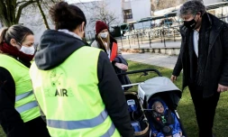 Le professeur Roeland Samson, de l'Université d'Anvers (à d.) donne des explications aux volontaires venus se promener avec Claire, une poupée équipée de capteurs pour mesurer la pollution de l'air, à Anvers (Belgique) le 25 janvier 2021.