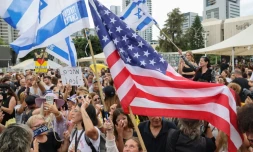 Des personnes agitent des drapeaux israéliens et américains sur la place des otages à Tel-Aviv le 9 octobre, après l'annonce d'un accord entre Israël et le Hamas
